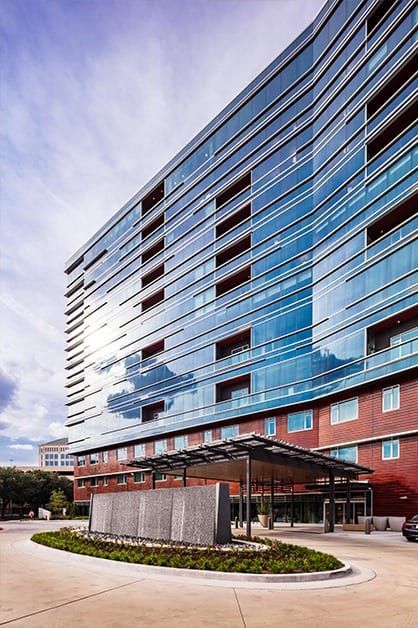 A modern building with a glass facade reflecting the sky.