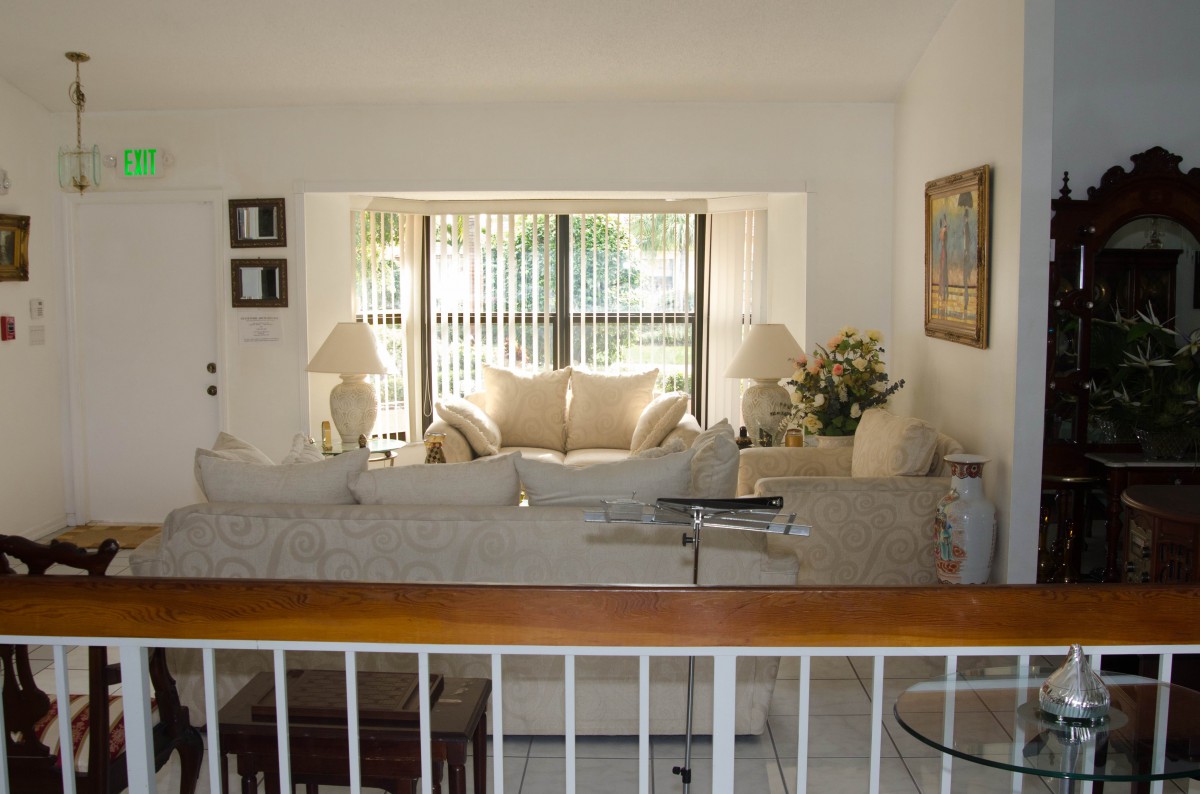 A cozy living room with natural light streaming through large windows, featuring a comfortable sofa and elegant decor.
