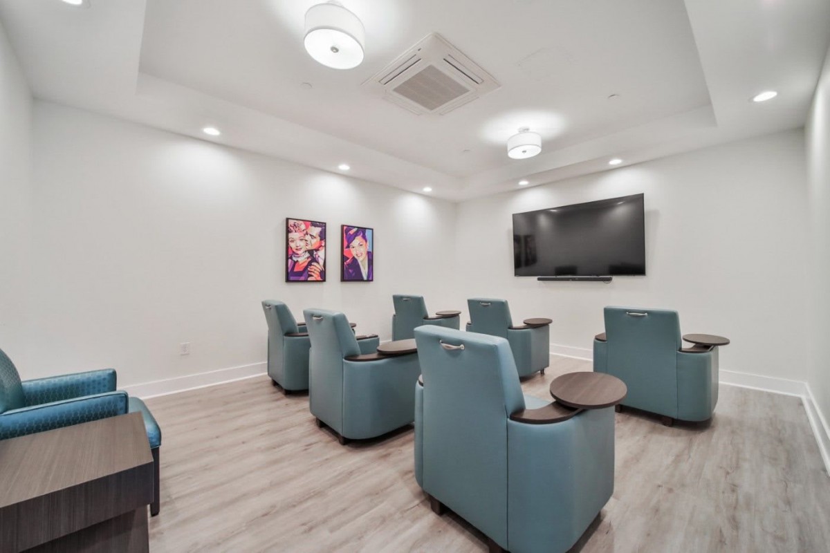 A modern home theater setup with recliner chairs and a large screen.
