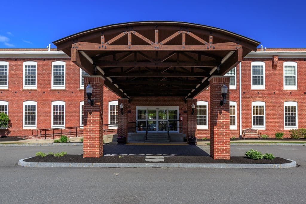 A symmetrical building entrance with a brick facade and wooden canopy.