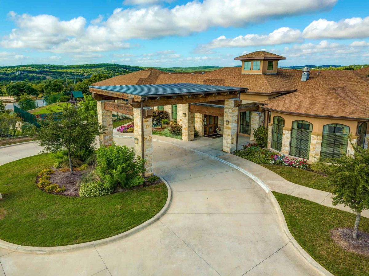 A luxurious countryside house with a spacious driveway and beautiful landscaping.