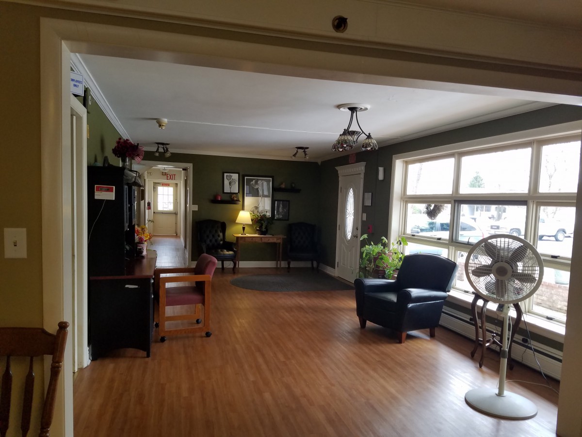 A cozy living room with seating arrangements and large windows.