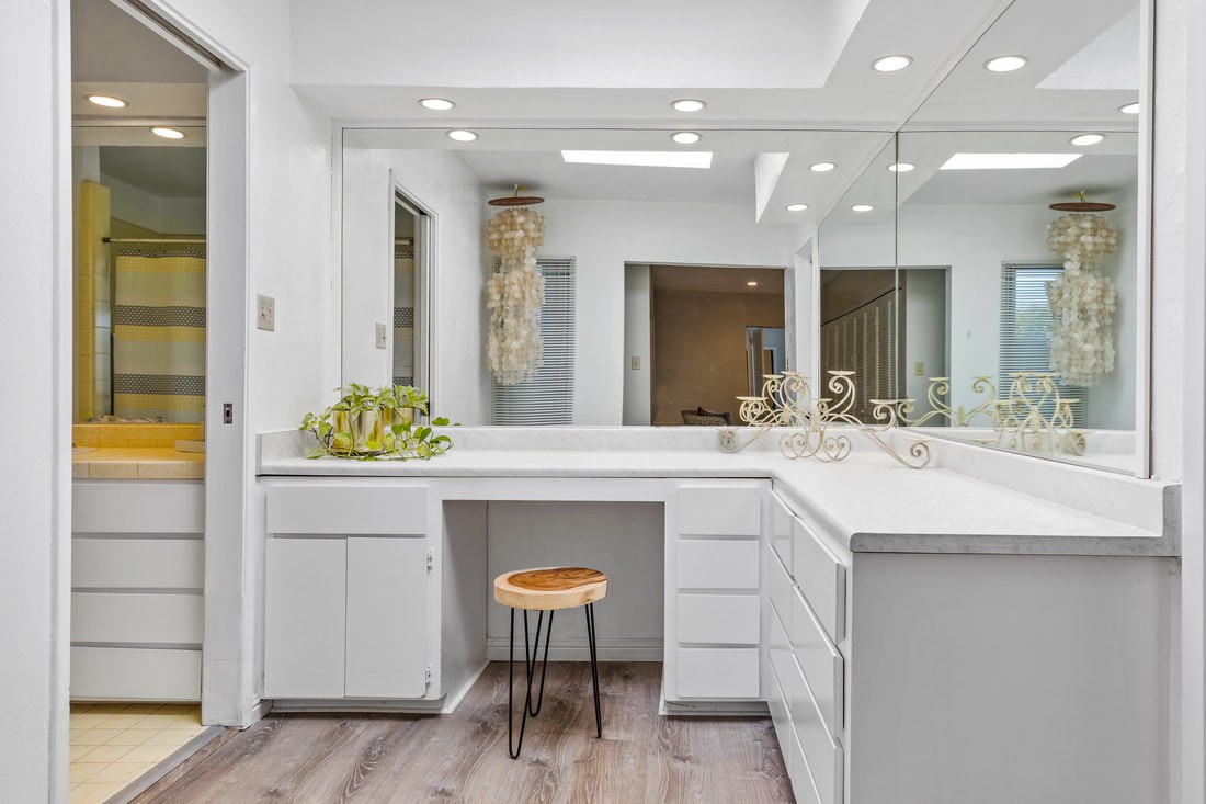A modern bathroom vanity with bright lighting and minimalist design.