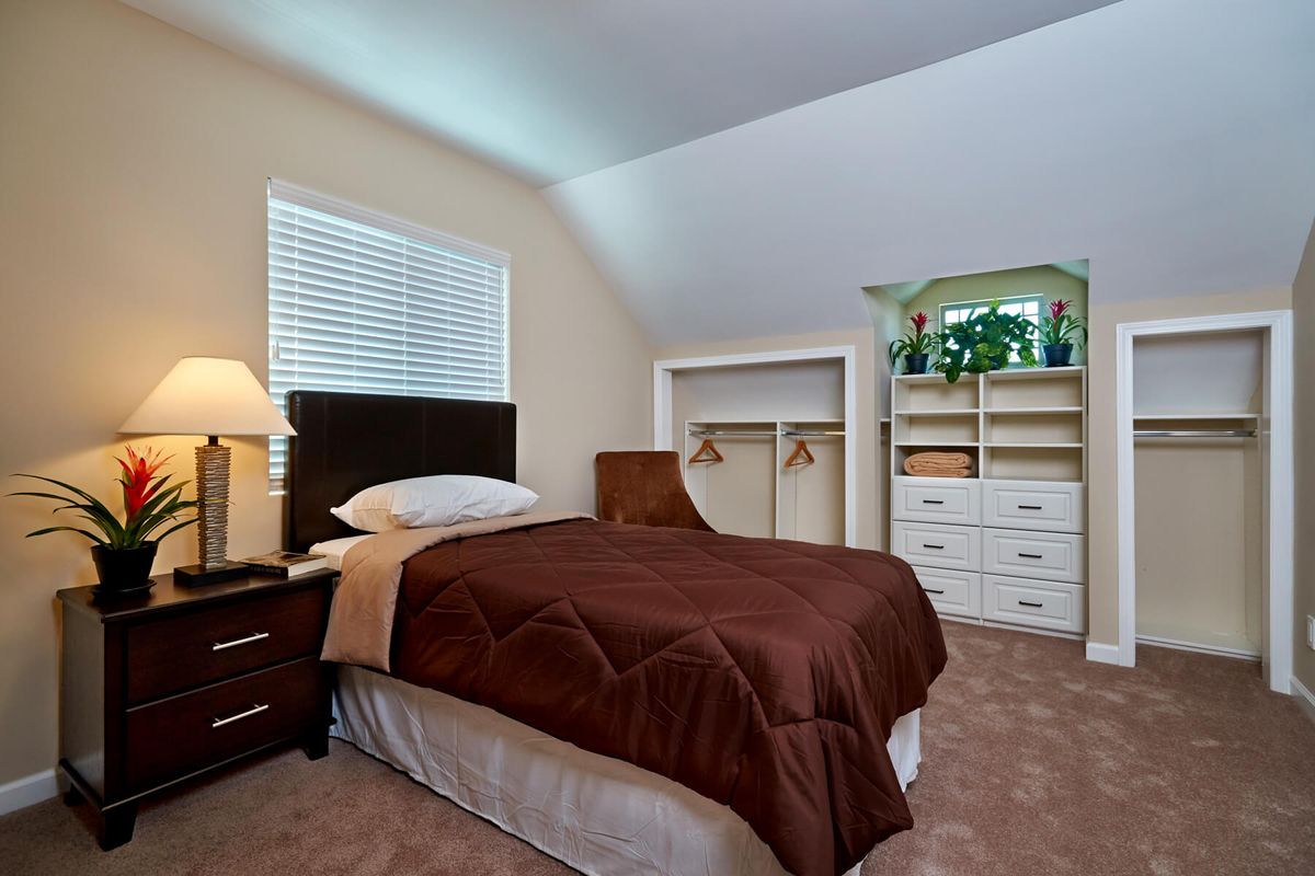 A cozy bedroom with a bed, nightstand, and neatly arranged closet.