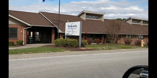 A view of a business building from the roadside, featuring a clear sign.