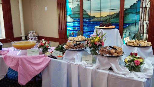 A beautifully arranged dessert buffet featuring an array of treats and floral decorations.