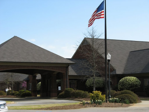 Entrance to a building with an American flag waving in front.