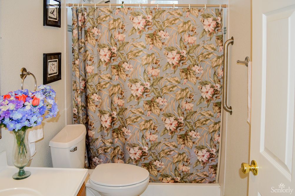 A bathroom featuring a floral pattern shower curtain and modern fixtures.
