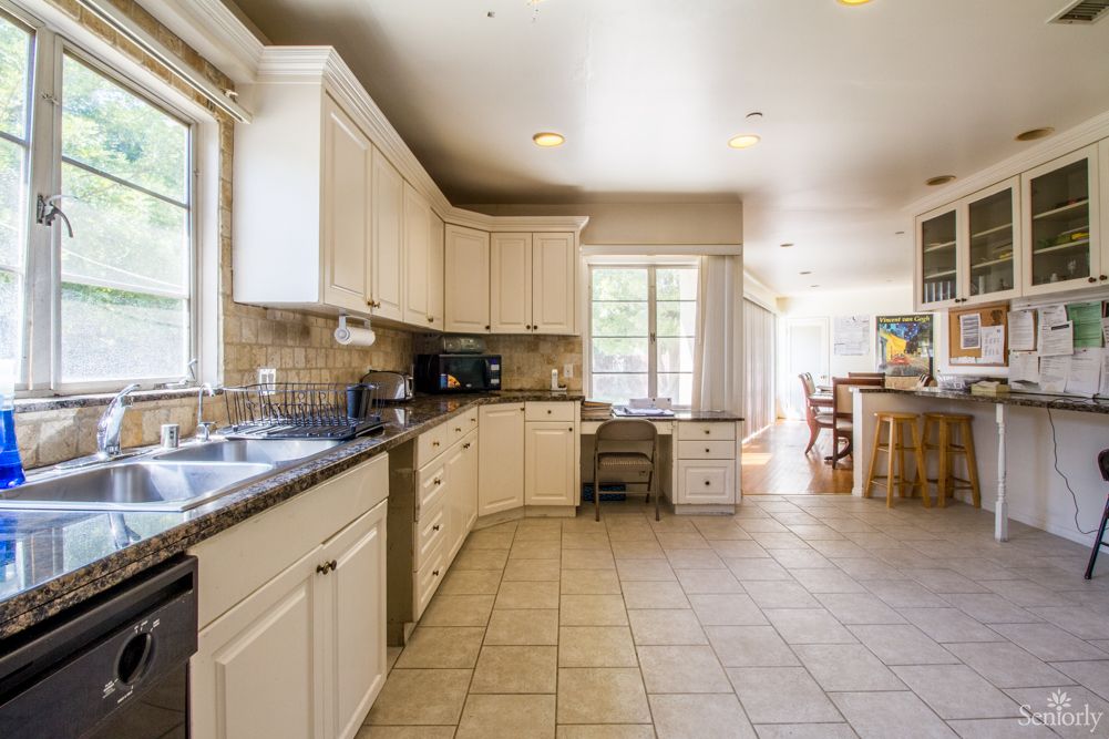 Spacious kitchen with white cabinets, ample counter space, and a dining area.