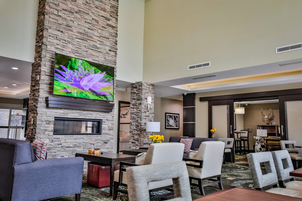 A modern lobby with comfortable seating and a large television display.