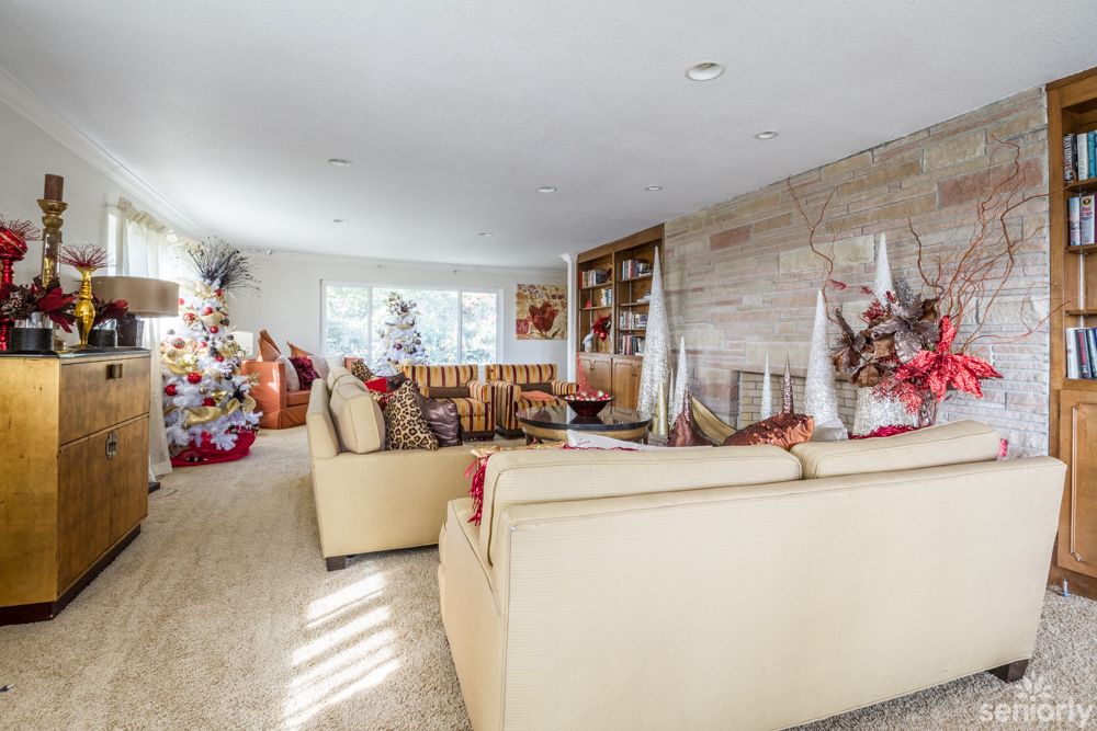 A cozy living room decorated for the holidays with a Christmas tree and warm furnishings.