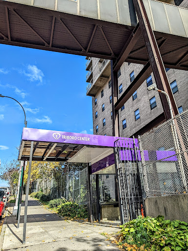 The entrance of a modern residential building featuring prominent purple signage.