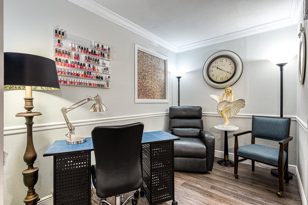 A cozy nail salon interior featuring a manicure station, recliner chair, and stylish decor.