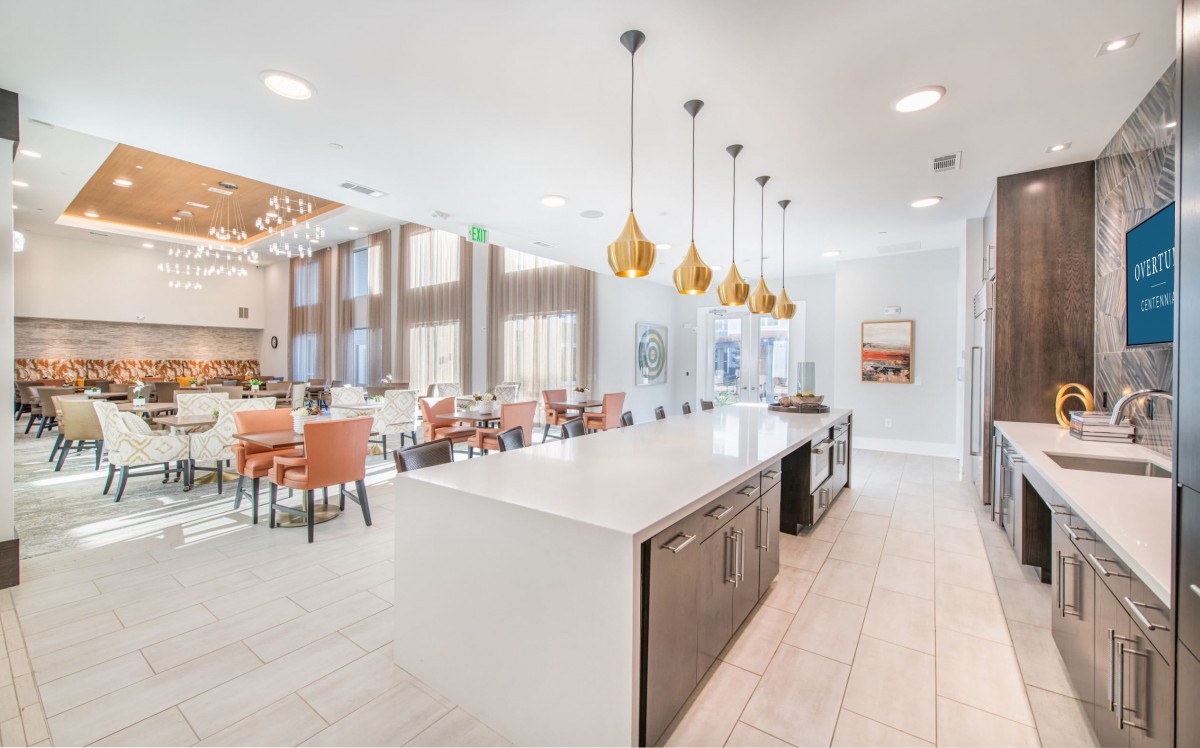 A modern kitchen and dining area with stylish pendant lights and an island countertop.