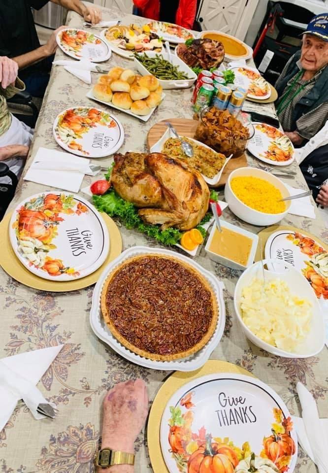 A festive Thanksgiving dinner table set with a roasted turkey, pecan pie, mashed potatoes, and other traditional dishes.