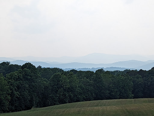 A serene view of rolling hills and distant mountains shrouded in haze.