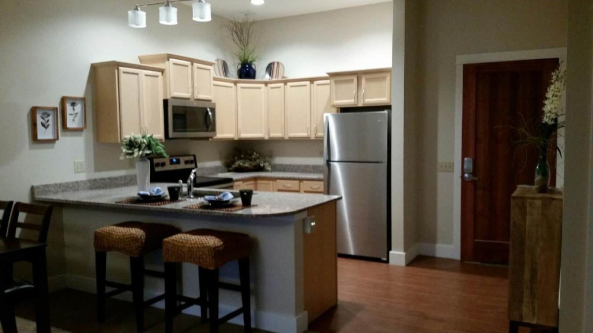 A modern kitchen with wooden cabinets and stainless steel appliances.