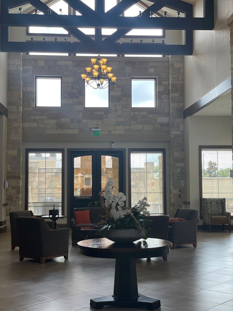 A spacious lobby with comfortable seating and a chandelier.