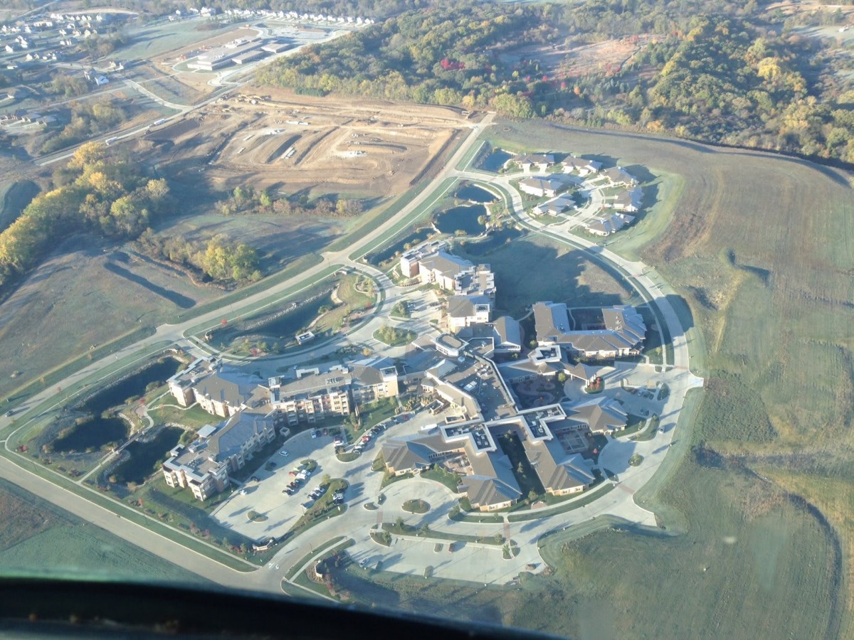 Aerial view of a building complex with surrounding roads and landscape.