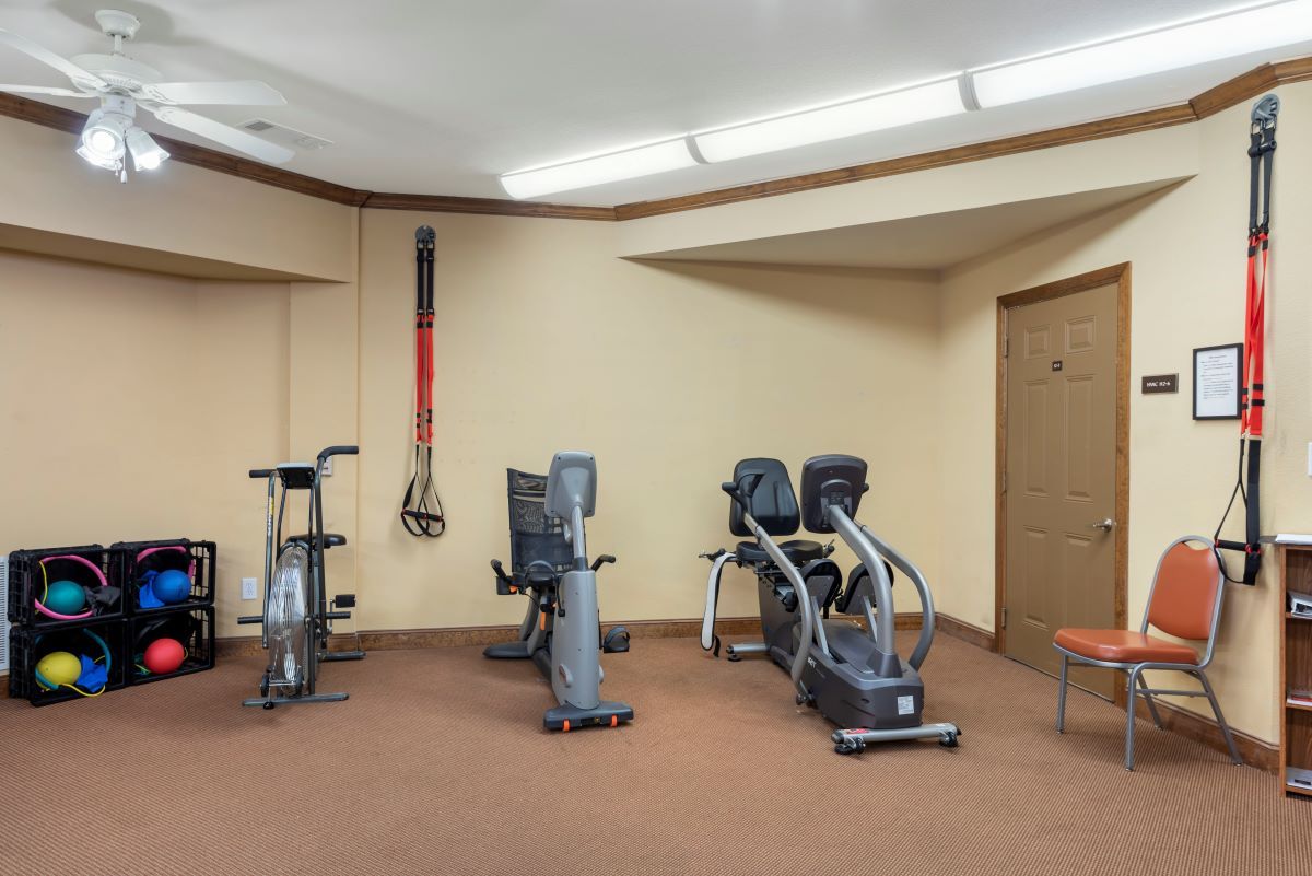 A small gym with various exercise equipment, including a stationary bike and treadmill.