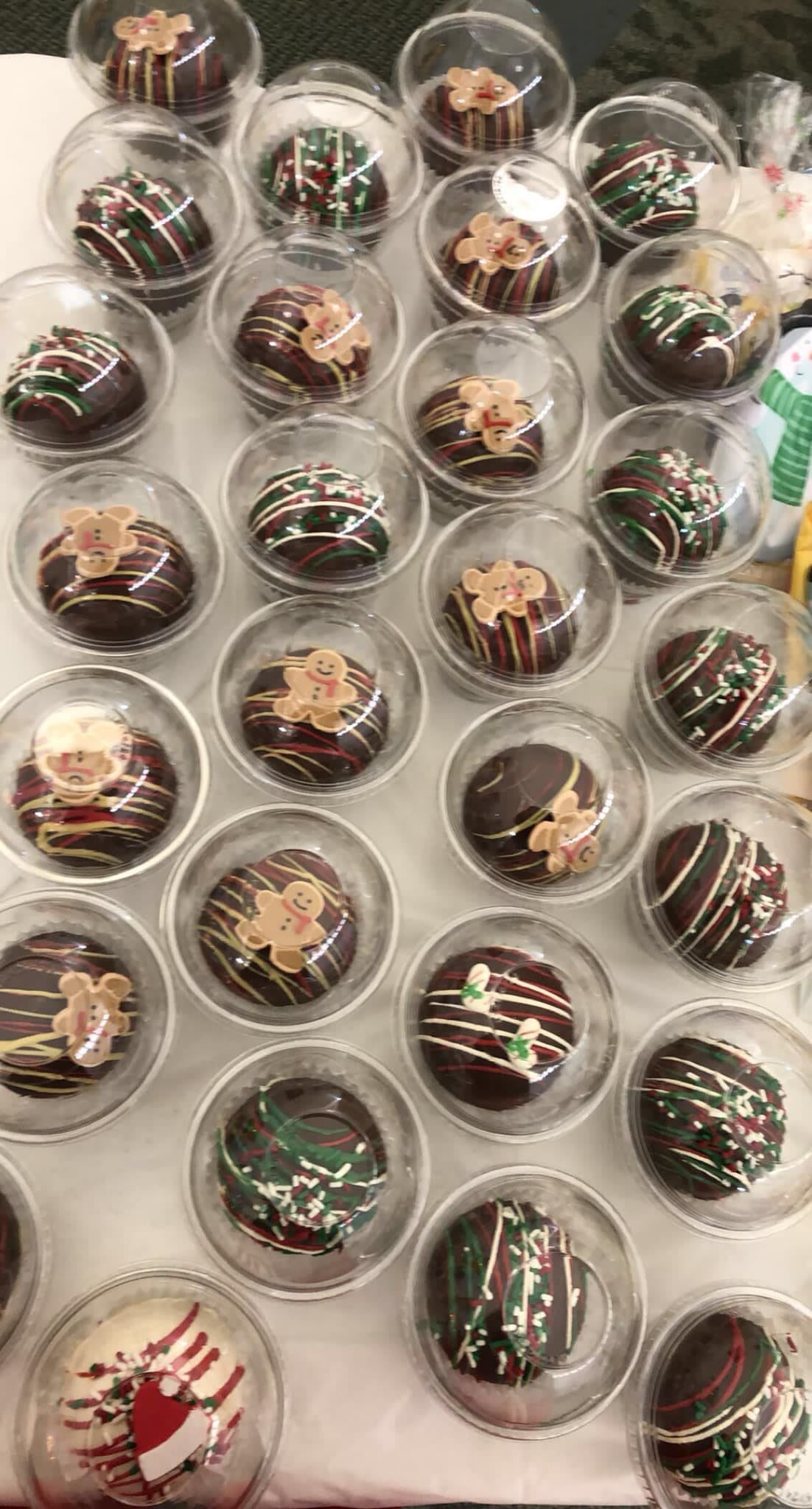 A selection of beautifully decorated gourmet chocolates displayed in clear cups.