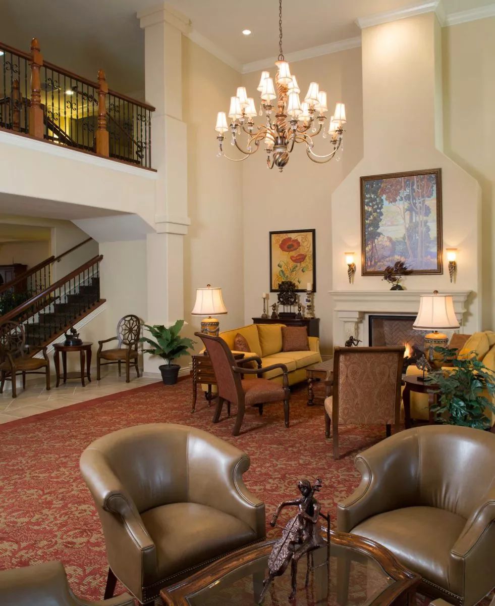 A spacious hotel lobby with elegant seating and a grand chandelier.