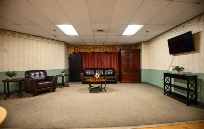 A spacious living room with comfortable sofas and a central coffee table, adorned with patterned curtains.