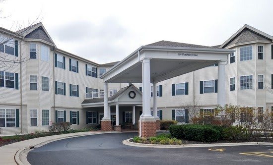 A residential building with an entrance featuring large columns and a circular driveway.