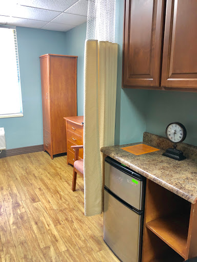 A kitchenette area featuring wooden furniture and modern amenities.
