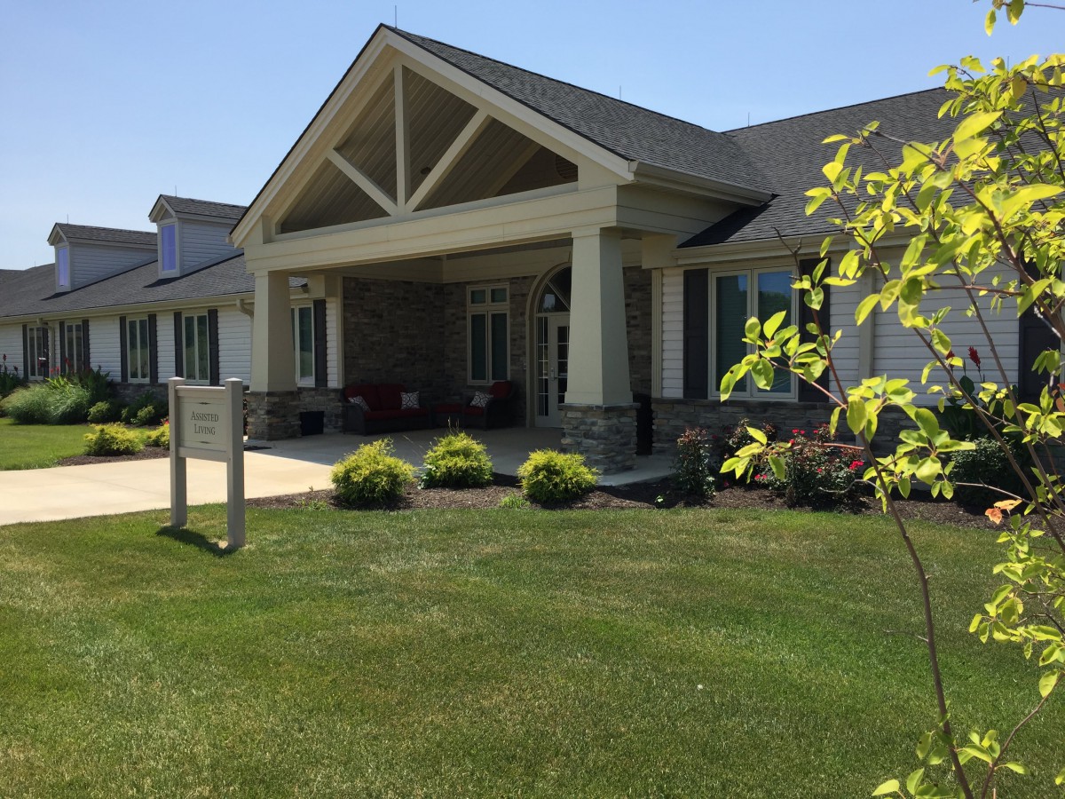 A well-maintained building entrance with a landscaped lawn.