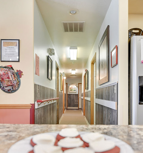 A cozy hallway view from a kitchen area, adorned with framed artwork and inviting lighting.