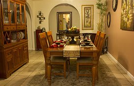 A warmly decorated dining room with a set table and wooden furniture.