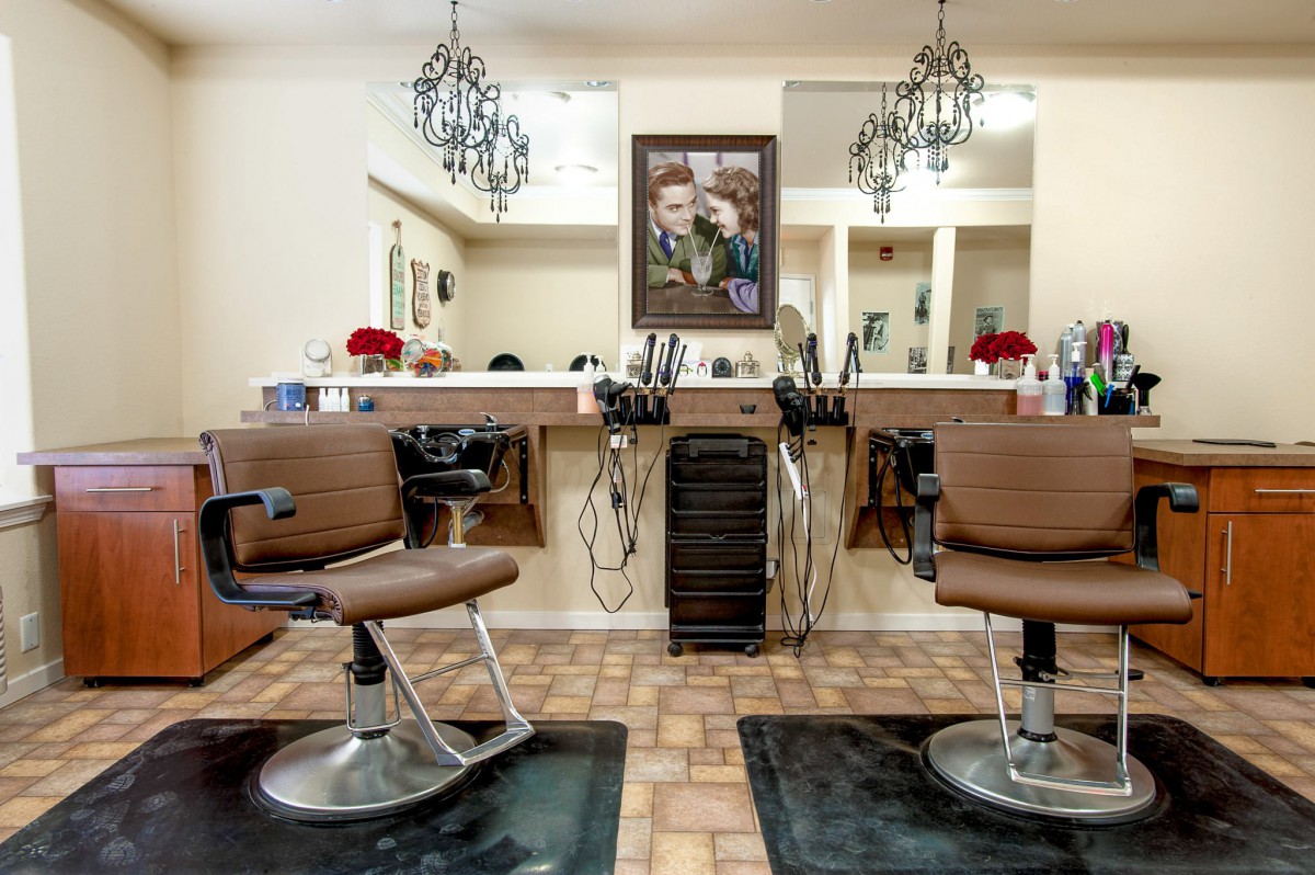 A cozy barbershop interior with chairs and mirrors lined up for customers.