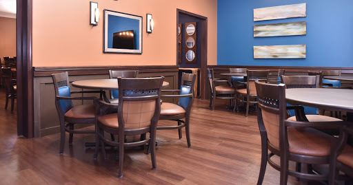 A cozy restaurant interior featuring wooden furniture, warm-colored walls, and tasteful decor.