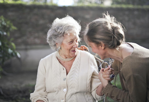 A joyful moment shared between two women, filled with laughter and warmth in an outdoor setting.