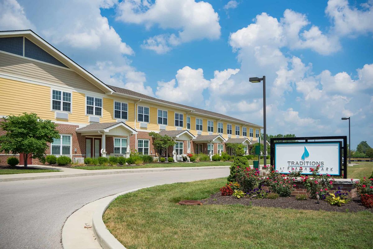 A long building with a well-manicured lawn and a clear blue sky in the background.