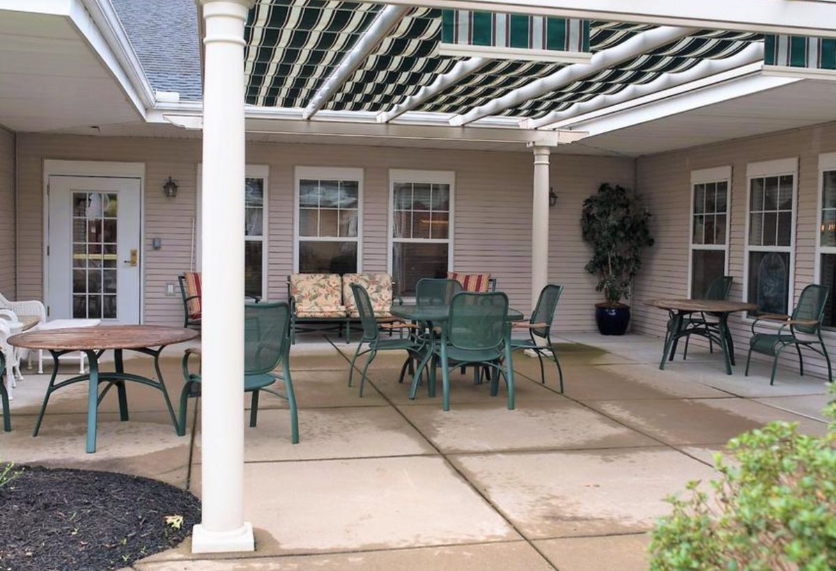 A cozy patio with outdoor furniture under a pergola.