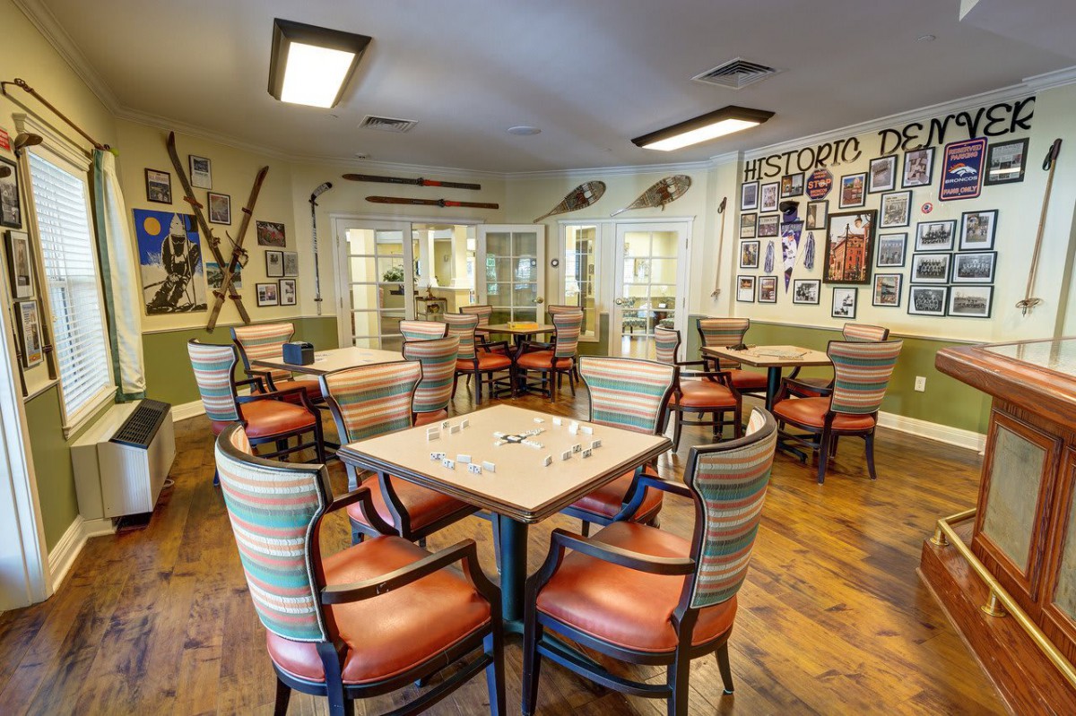 A cozy community room with colorful chairs and tables, adorned with various wall decorations.