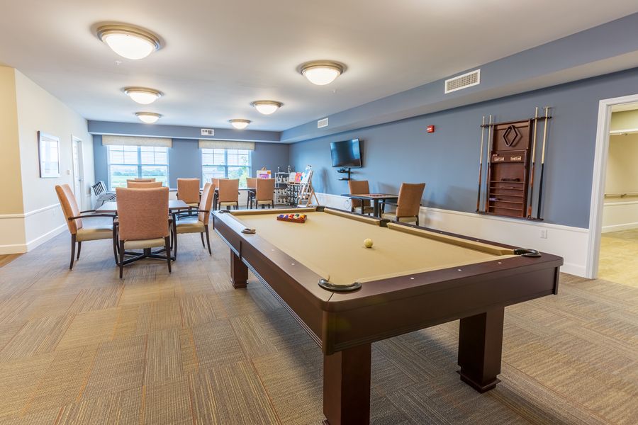 A spacious game room featuring a pool table and comfortable seating.