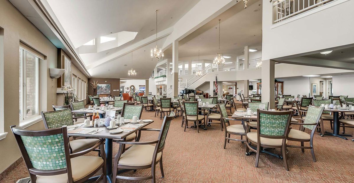 A spacious and well-lit dining room featuring neatly arranged tables and chairs.