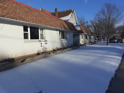 A serene winter scene showcasing houses covered in a blanket of snow under a clear blue sky.