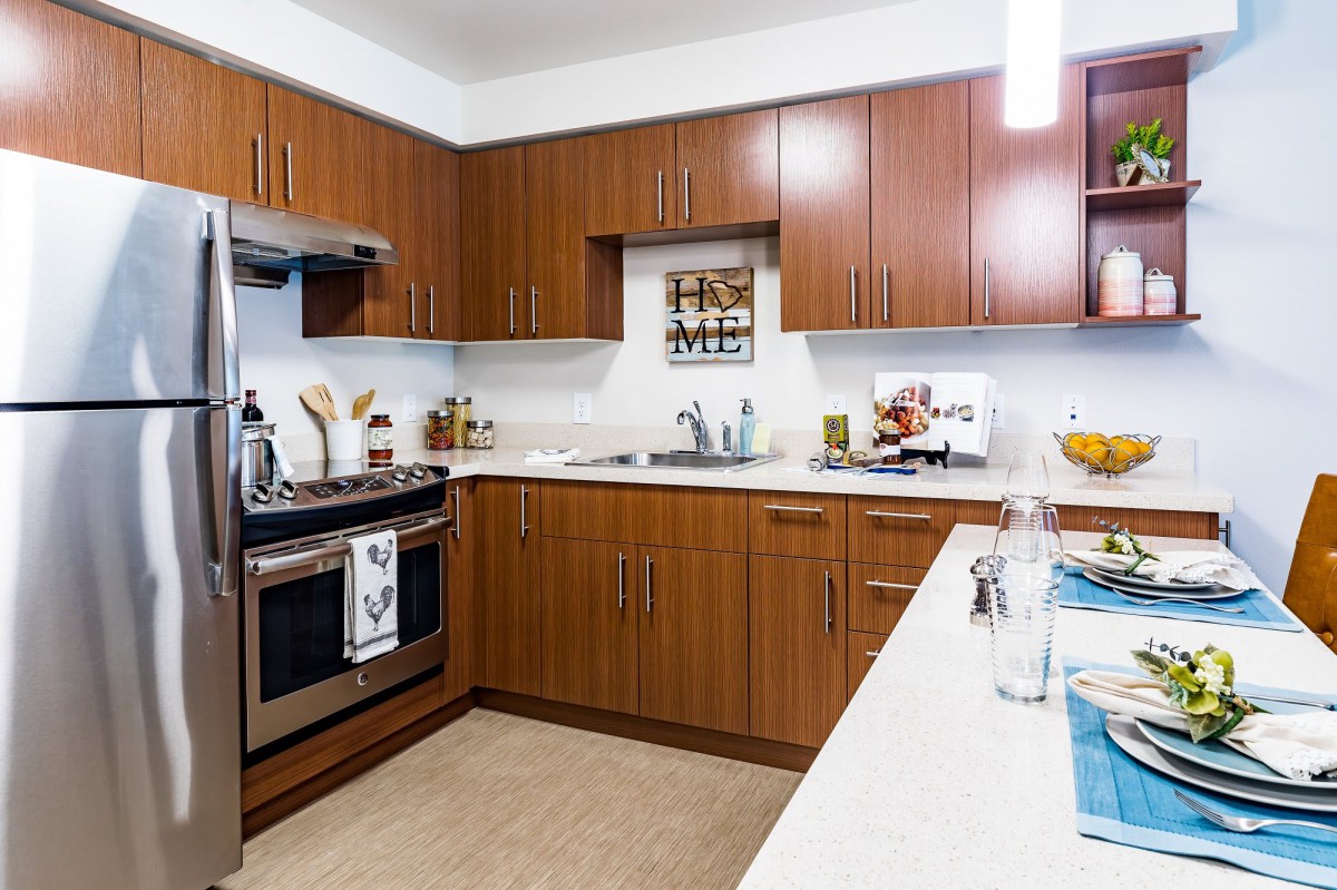 A modern kitchen with wooden cabinets and stainless steel appliances.