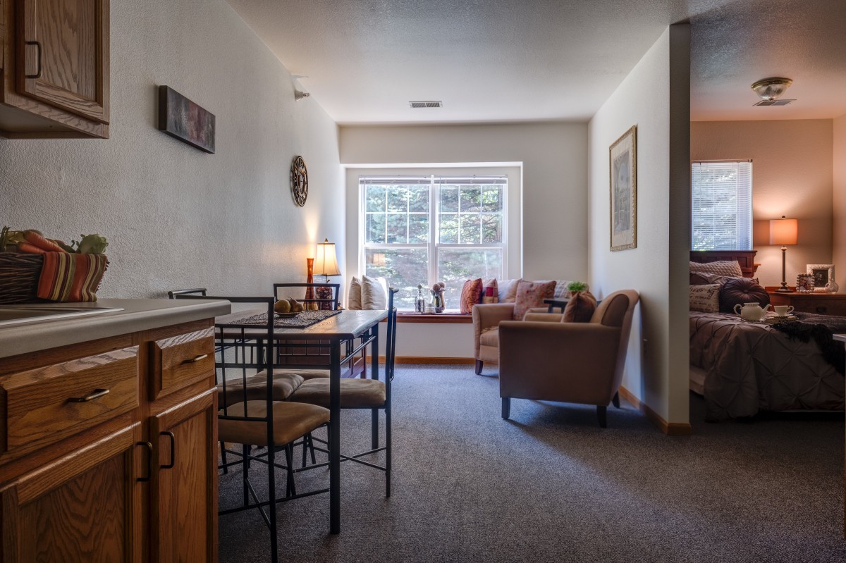 A cozy interior featuring a living and dining area with natural light from a large window.