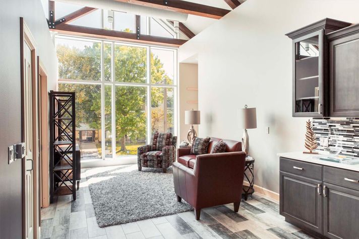 A modern living room with large windows, natural light, and stylish furniture.