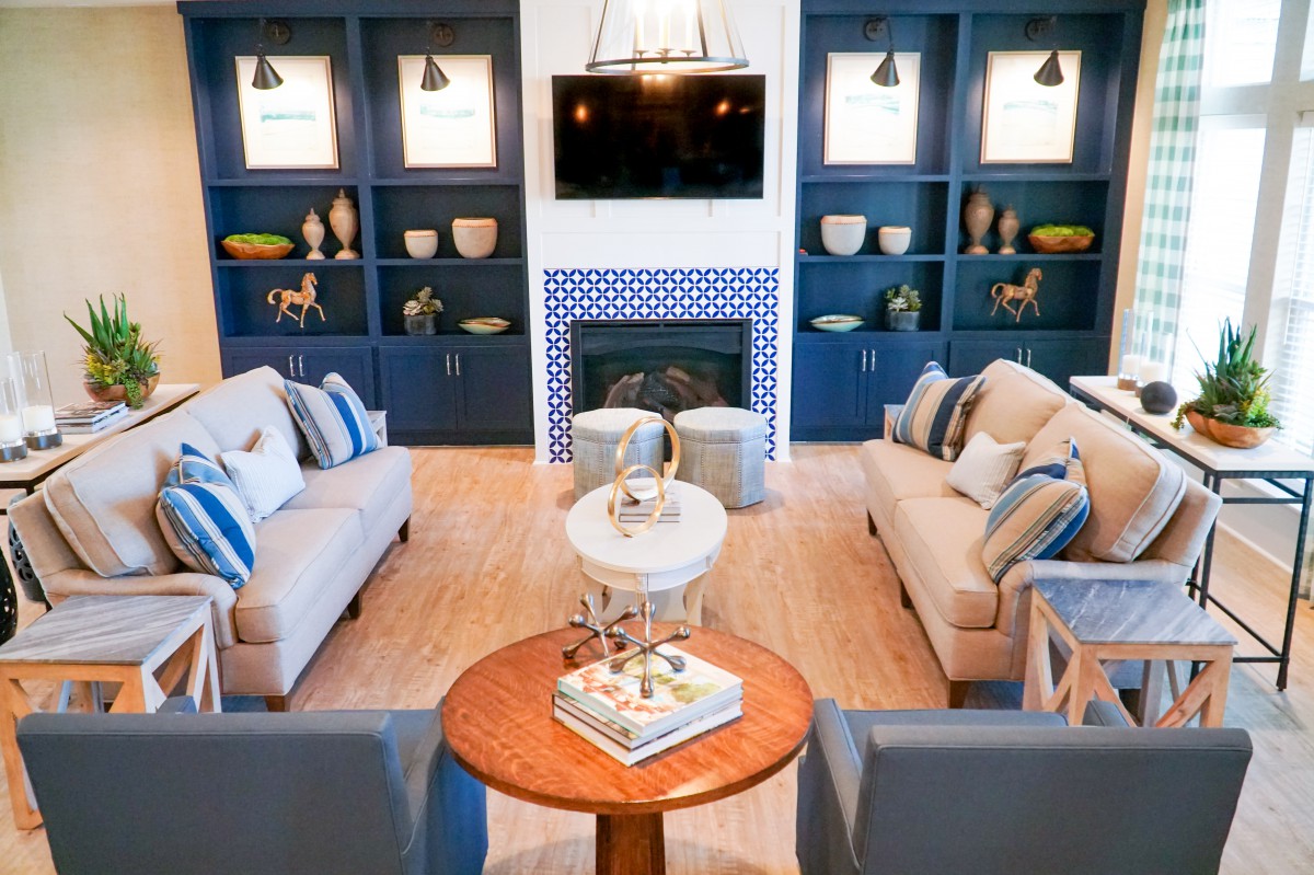 A modern living room with blue accents, featuring a cozy fireplace and stylish shelving.