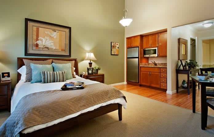 A cozy bedroom with a modern kitchenette and stylish decor.