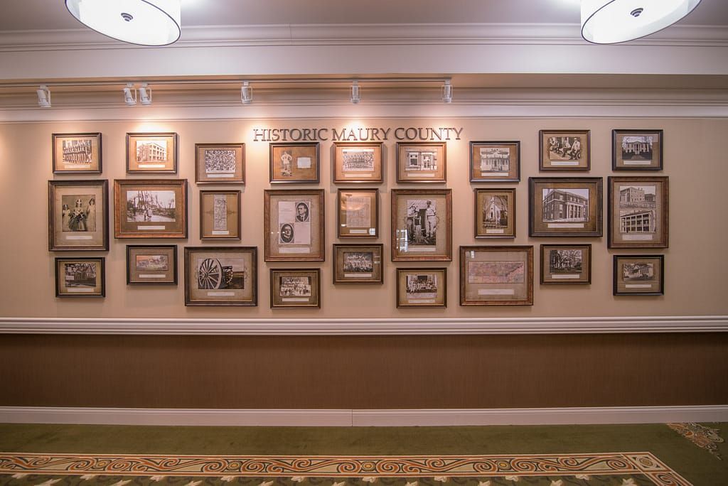 A hallway wall adorned with a collection of framed historical photographs.