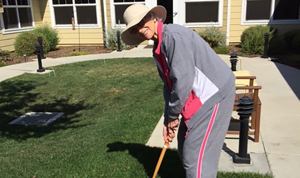 A person playing croquet in a garden.