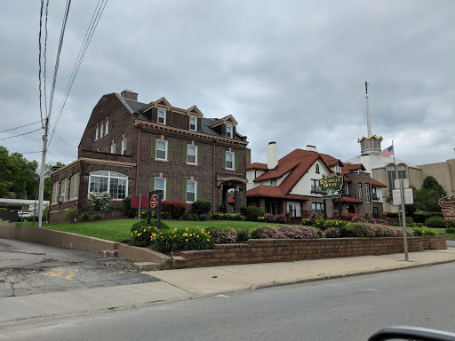 A charming blend of architectural styles, featuring a well-kept front yard under a cloudy sky.