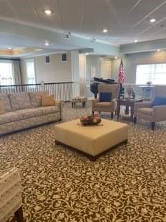 A cozy living room with sofas and chairs arranged around a central coffee table.